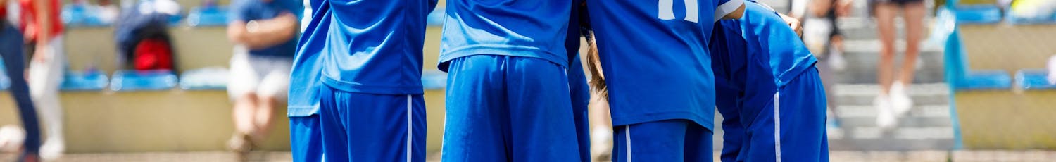 Nuoret pojat pelaavat jalkapalloa.